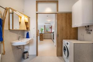 a bathroom with a sink and a washing machine at Alb-Sonne Ferienwohnung in Sonnenbühl