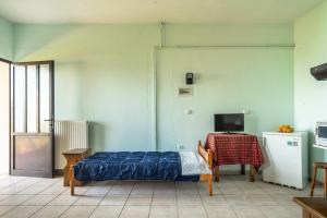 a bedroom with a bed and a table and a television at Vangelis studio 1 in Kefalonia