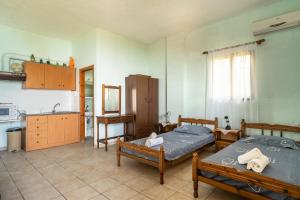 a bedroom with two beds and a kitchen with a sink at Vangelis studio 1 in Kefalonia +12 photos