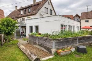 a white house with a garden in the yard at Alb-Sonne Ferienwohnung in Sonnenbühl
