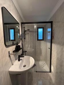 a bathroom with a sink and a shower with a mirror at Appartment Patricia in Orba +16 photos