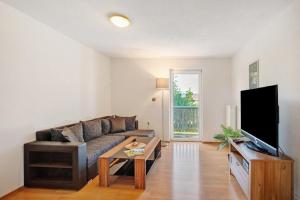 a living room with a couch and a tv at Ferienwohnungen große Albferien in Heroldstatt