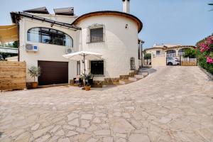 a large white house with an umbrella on a driveway at Appartment Patricia in Orba