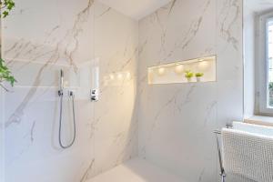a bathroom with a shower with marble walls at Haus Alpenveilchen - Appartement 2 in Schönau am Königssee +12 photos