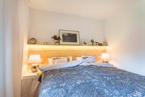 a bedroom with a blue bed with two lamps at Haus Alpenveilchen - Appartement 2 in Schönau am Königssee