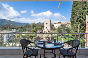 a table and chairs on a balcony with a view at Panorama Apartments in Skoutari