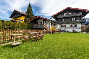a house with a table and chairs in the yard at Haus Alpenveilchen - Appartement 2 in Schönau am Königssee
