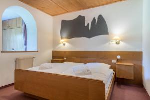 a bedroom with a bed with a bat on the wall at Sabina Dolomites Schlern in Alpe di Siusi +21 photos