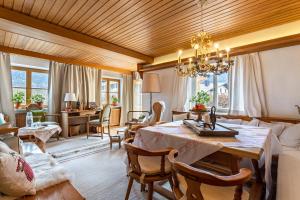 a dining room with a table and a living room at Haus Alpenveilchen - Appartement 2 in Schönau am Königssee
