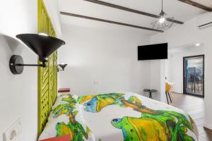 ein Schlafzimmer mit einem Bett, auf dem ein Gemälde hängt in der Unterkunft Loft Lisara y Limami in Telde