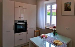 a kitchen with a table and a white cabinet at Villa Karlsbach in Teisendorf +25 photos
