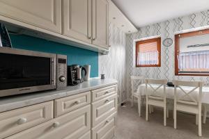 a kitchen with a microwave and a table with chairs at Ferienwohnung Davio in Lohe-Rickelshof