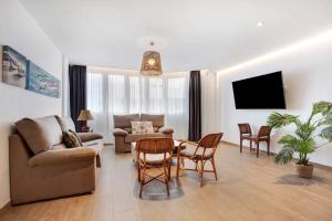 a living room with a couch and a table and chairs at Falco 2 in La Oliva