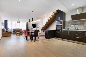 a kitchen and living room with a table and a staircase at Falco 2 in La Oliva