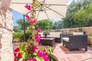 a patio with pink flowers and an umbrella at Casale siculo in Avola