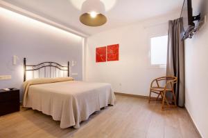 a white bedroom with a bed and a window at Falco 2 in La Oliva +24 photos