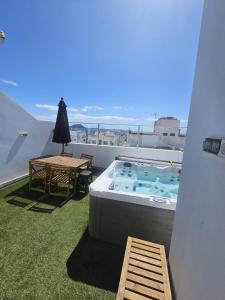 a balcony with a hot tub and a picnic table at Falco 2 in La Oliva