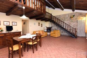 a living room with a table and chairs and a staircase at La Valle Del Sole - Val D'Orcia in Castiglione dʼOrcia