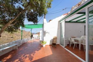 a patio with a table on the side of a house at Casa Cueva Tejeda 2 dorm in Tejeda