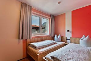 a bedroom with two beds and a window at Luisalle Top 6 in Auffach