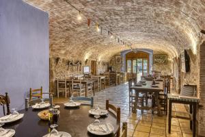 a restaurant with tables and chairs in a stone tunnel at Can Casadellà in Serra de Daró