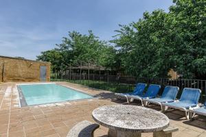 a patio with chairs and a table and a pool at Can Casadellà in Serra de Daró