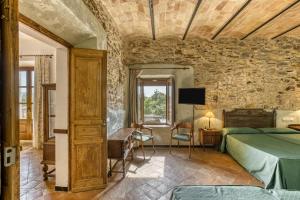 a bedroom with a bed and a stone wall at Can Casadellà in Serra de Daró