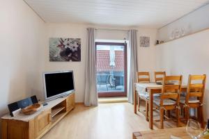 a living room with a television and a table and chairs at Ferienhaus am Blumengässle in Feldberg