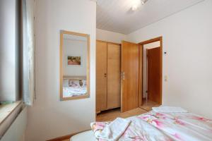 a bedroom with a bed and a mirror at Ferienhaus am Blumengässle in Feldberg