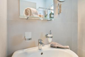 a bathroom with a sink and a mirror at Panorama Apartments in Skoutari