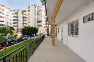 a walkway in a building with buildings in the background at Apartamentos Sealmar Moliere in Málaga