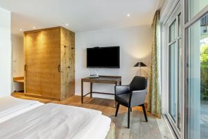 a bedroom with a bed and a desk and a television at Doppelzimmer Mit Terrasse in Schmallenberg
