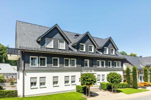 a large house with a black roof at Doppelzimmer Mit Terrasse in Schmallenberg