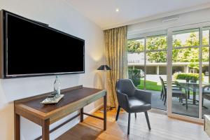 a living room with a tv and a desk and a chair at Doppelzimmer Mit Terrasse in Schmallenberg +10 photos