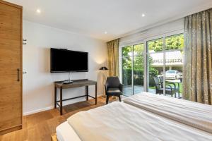 a bedroom with a bed and a flat screen tv at Doppelzimmer Mit Terrasse in Schmallenberg