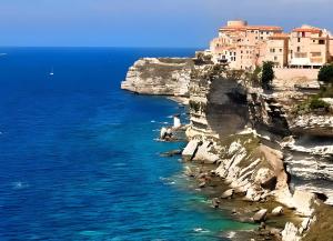 a town on a cliff next to the ocean at Studio pieds dans l'eau in Grosseto-Prugna