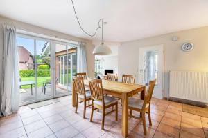 a dining room with a wooden table and chairs at Ferienhaus Sprante in Brunsbüttel