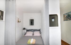 a small white room with two beds in it at Studio pieds dans l'eau in Grosseto-Prugna