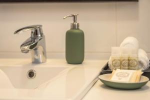 a bathroom sink with a bottle of soap and a plate at Casa da Olides - T3 in Santana +20 photos