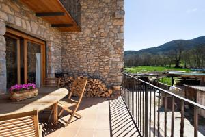 a patio with a wooden table and chairs on a balcony at Mas Cal Gintó in Das
