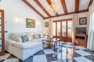 a living room with a couch and a tv at Villa Manrique in Cala Ratjada