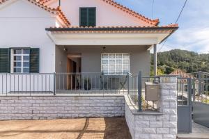 a house with a balcony and a gate at Casa da Olides - T3 in Santana
