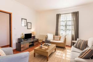 a living room filled with furniture and a tv at Casa da Olides - T3 in Santana