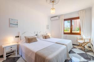 two beds in a white room with a window at Villa Manrique in Cala Ratjada +22 photos