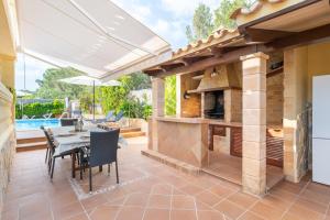 a patio with an outdoor kitchen with a table and chairs at Villa Manrique in Cala Ratjada