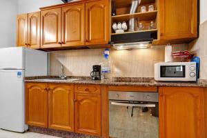 a kitchen with wooden cabinets and a white refrigerator at Casa Alexis in Lajita +15 photos