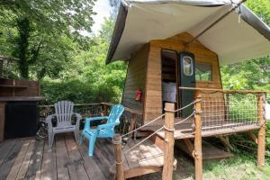 a cabin with two chairs and an umbrella on a deck at la pêcherie in Malbosc