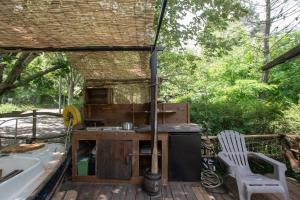 an outdoor kitchen with a table and a chair on a deck at la pêcherie in Malbosc