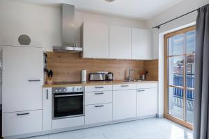 a kitchen with white cabinets and a refrigerator at Ferienwohnung Maria in Gilching