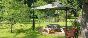 a gazebo with a bench in a park at Ferienhaus Schatz in Siedlung Schönwalde +15 photos